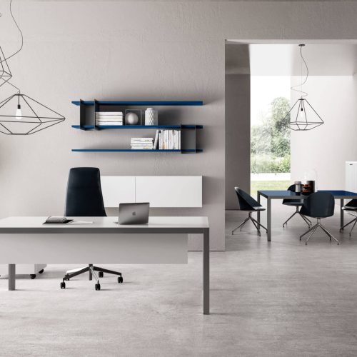 Ufficio di colore prevalentemente grigio con porta oggetti sui muri, scrivania e sedia ergonomica