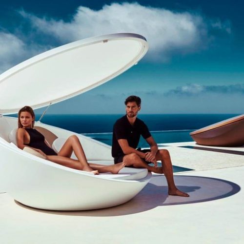 Una coppia che prende il sole in un lettino di design fatto ad oblò