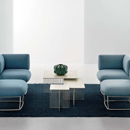 Due divanetti di colore azzurro, uno di fronte all'altro con in mezzo un tavolino