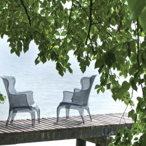 Due sedie su un molo con una cornice di foglie verdi